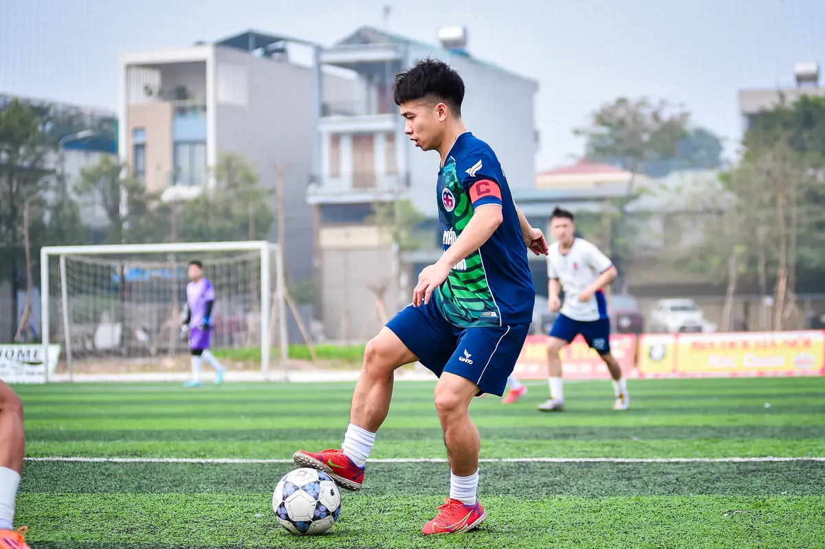 A young soccer player dribbles during a game on an artificial turf field in Hanoi, Vietnam.