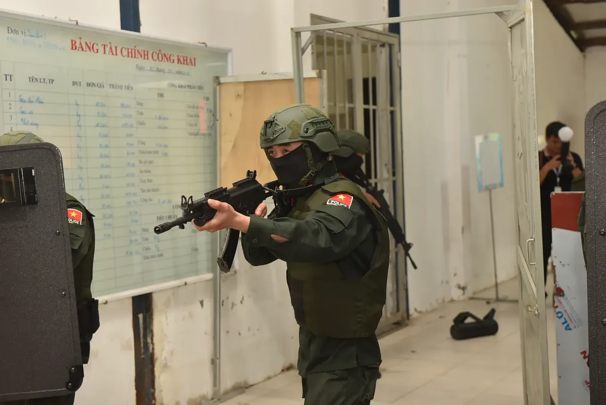 Armed military personnel in uniform conducting an indoor training exercise.