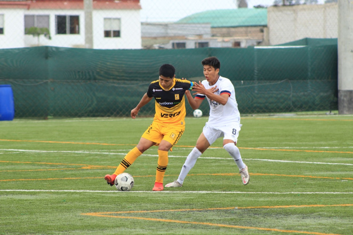 Two teenage soccer players compete fiercely on the field during a match.