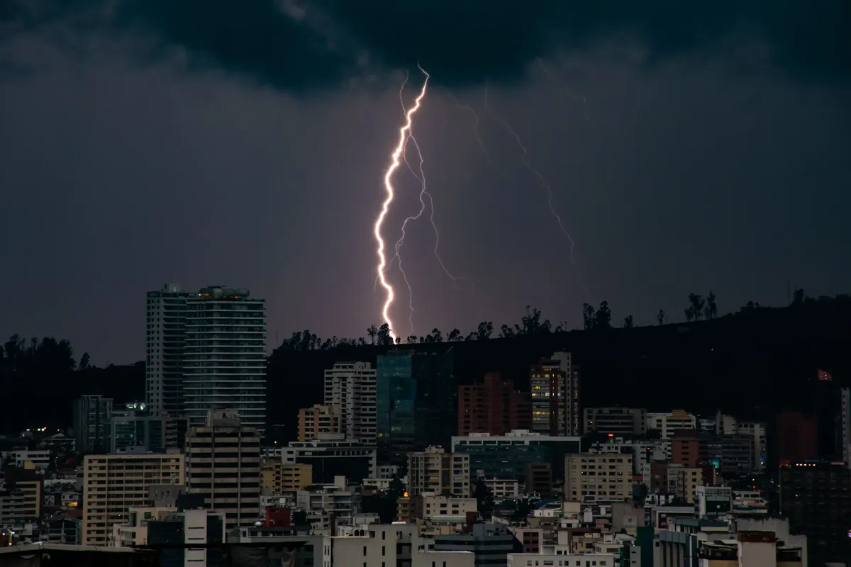 Captivating lightning storm over the Quito skyline during nightfall.