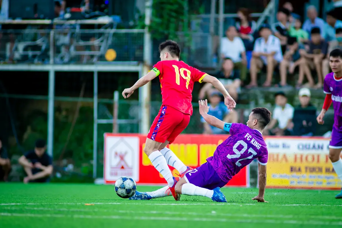 Exciting football match capture with players in action on a sunny day in Hanoi.