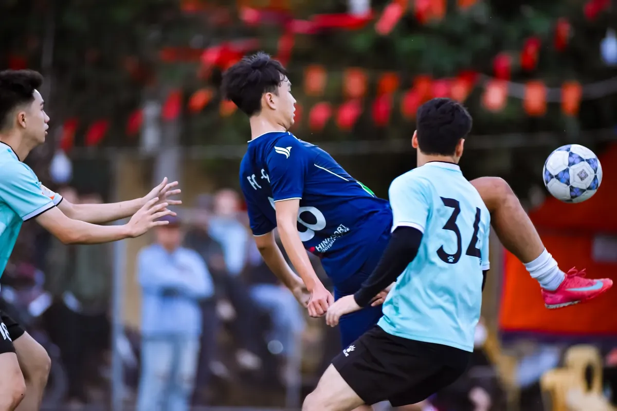 Energetic football players in action during a match in Hanoi, Vietnam.