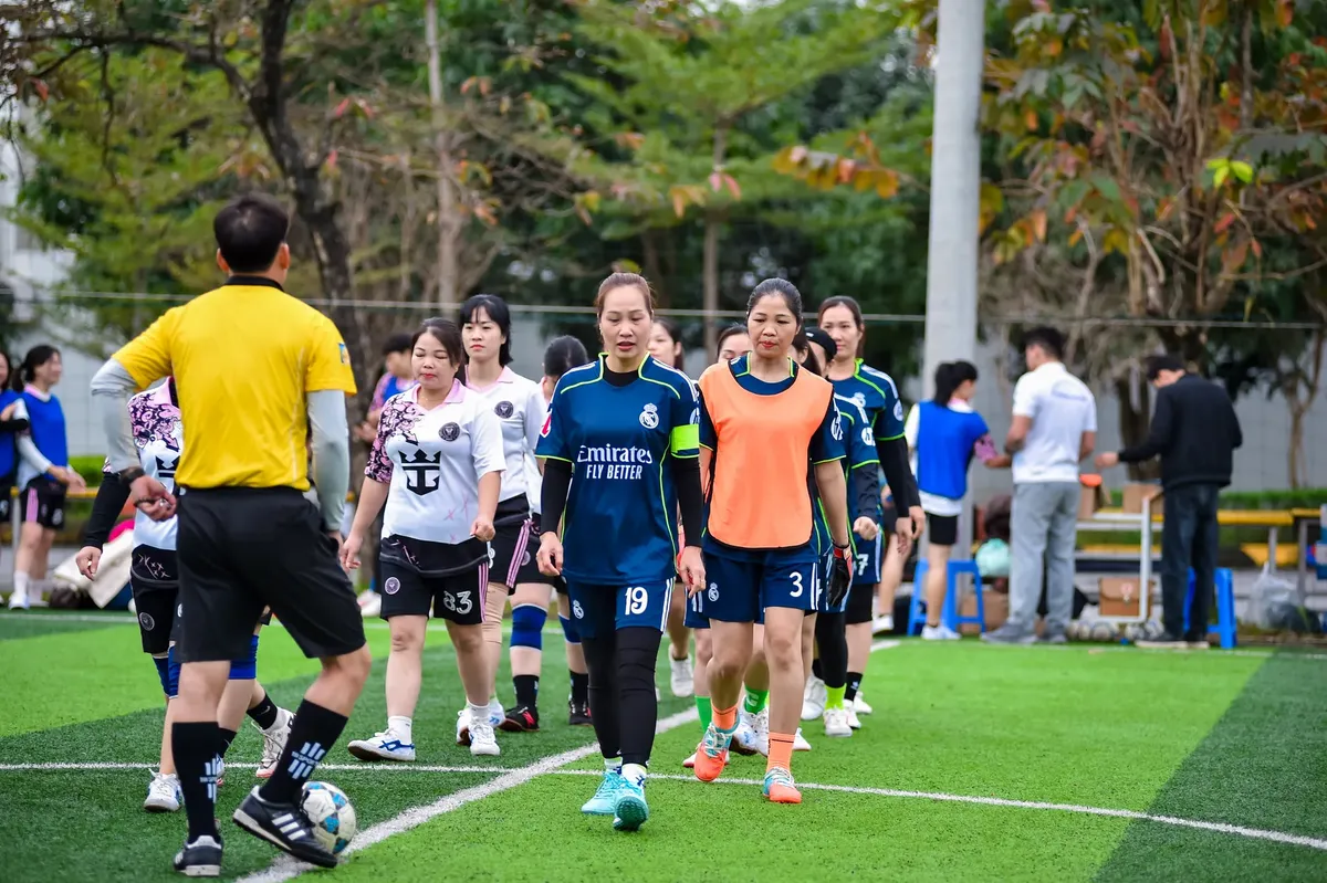 Women's football teams preparing for a match in Hanoi, Vietnam, showcasing team spirit and sportsmanship.