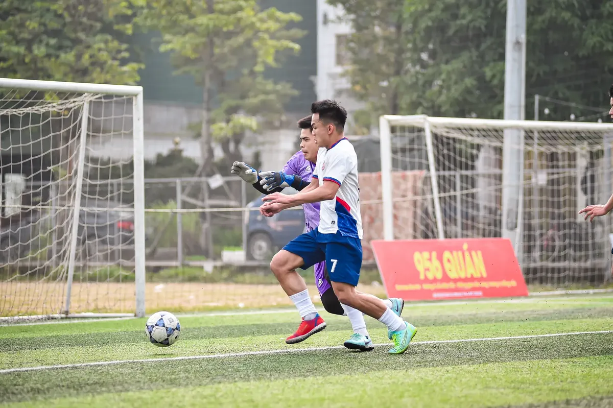 Dynamic moment of football players in action on a sports field in Hà Nội.