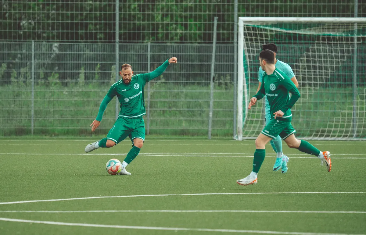 Players in green uniforms engage in a dynamic soccer match on a grassy field.