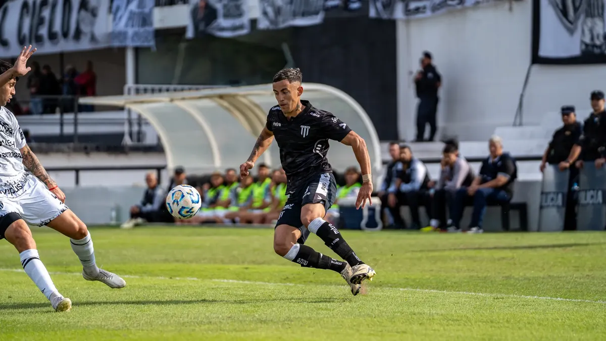 Soccer players in action during a competitive match on a sunny day.